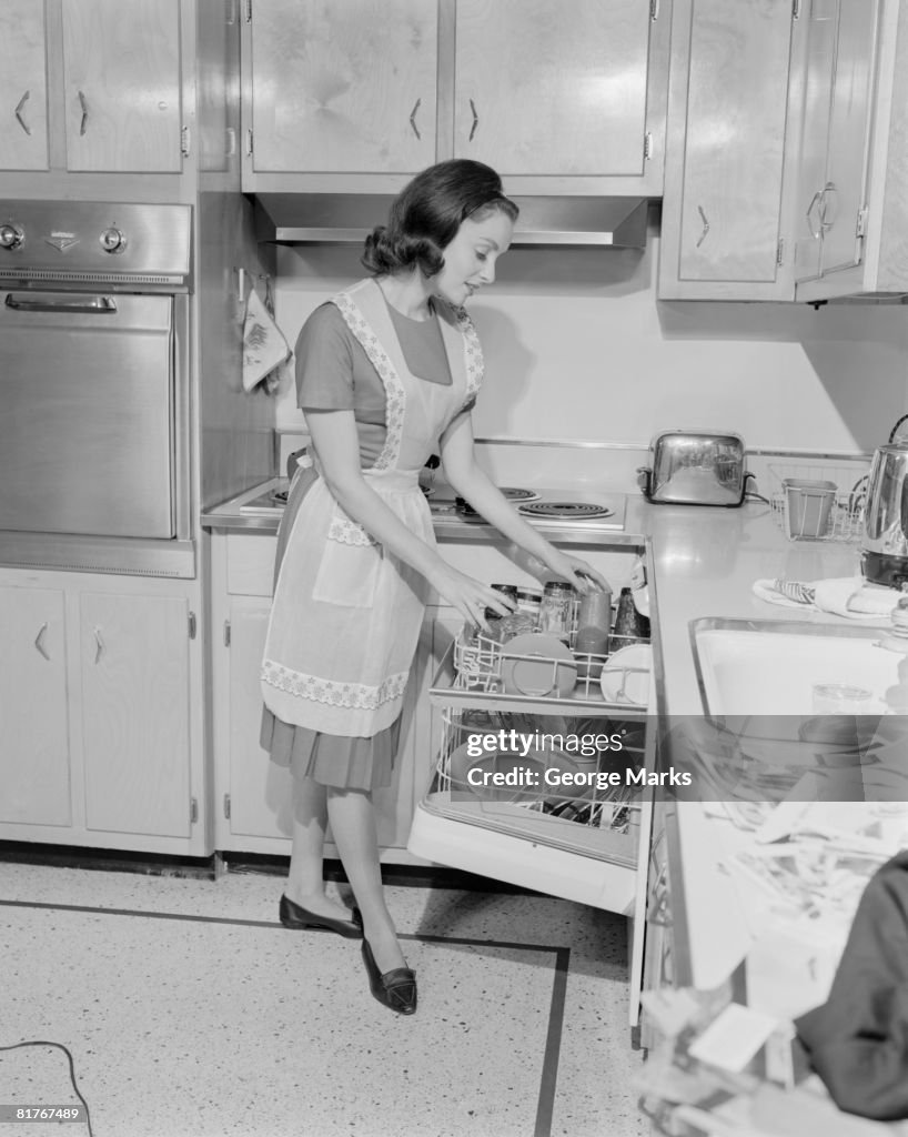 Woman putting dishes into dishwasher