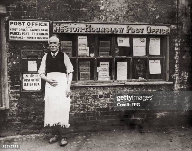 Postmaster outside his post office in Heston, Middlesex, circa 1925.
