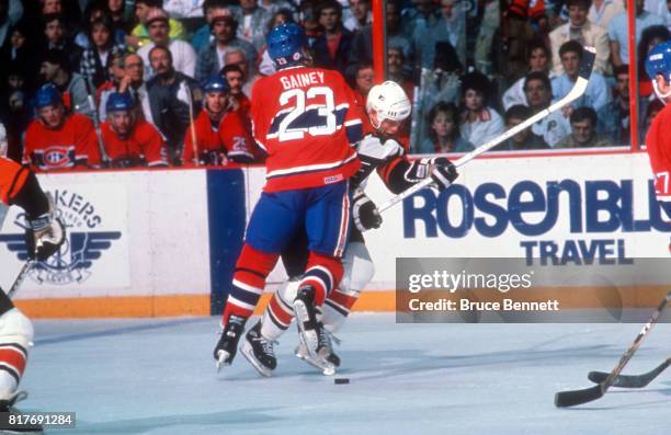 Bob Gainey of the Montreal Canadiens checks Mark Howe of the Philadelphia Flyers during an 1985 Conference Finals game circa May, 1989 at the...