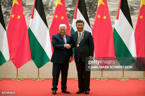 Palestinian President Mahmoud Abbas and Chinese President Xi Jinping shake hands during a signing ceremony at the Great Hall of the People in Beijing...