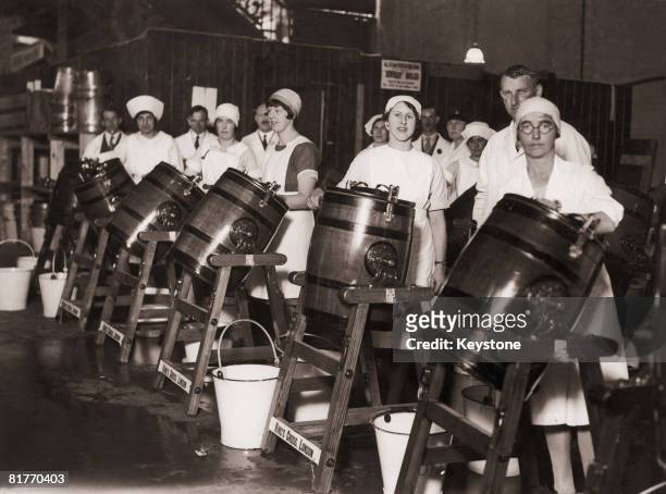 Dairy workers practise their butter-making before a dairy show at the Agricultural Hall, London, circa 1930.