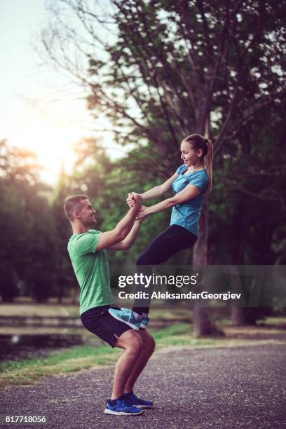casal atraente fazendo exercício de equilíbrio de fitness yoga pilates tag em parque público - tag 2 - fotografias e filmes do acervo