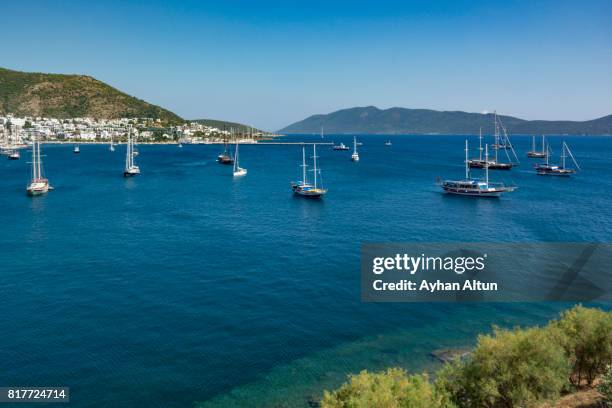 sailing boats anchored in turquoise waters of bodrum bay,near the st. peter castle,mugla province,turkey - mugla province stock pictures, royalty-free photos & images