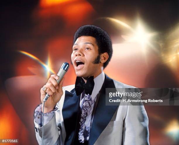 african-american man singing velvet collar tuxedo fashion long sideburns holding microphone singer. - sideburn stock pictures, royalty-free photos & images
