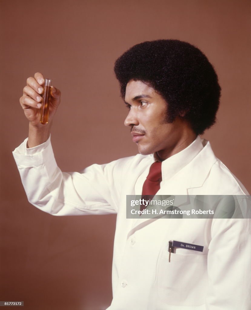 African-American Man Doctor Chemist Pharmacist Scientist Holding Up Test Tube Science Research Diagnostic.