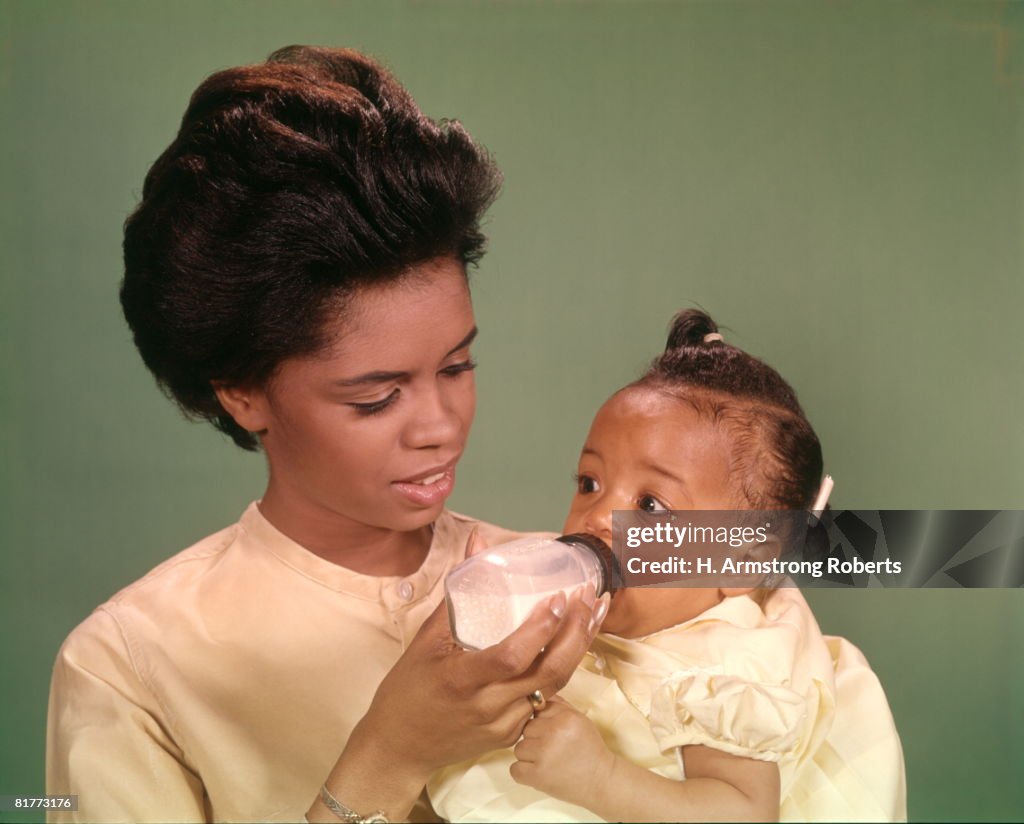 African-American Woman Mother Feeding Baby With Bottle Babies Women Mothers Family Families Parenting.