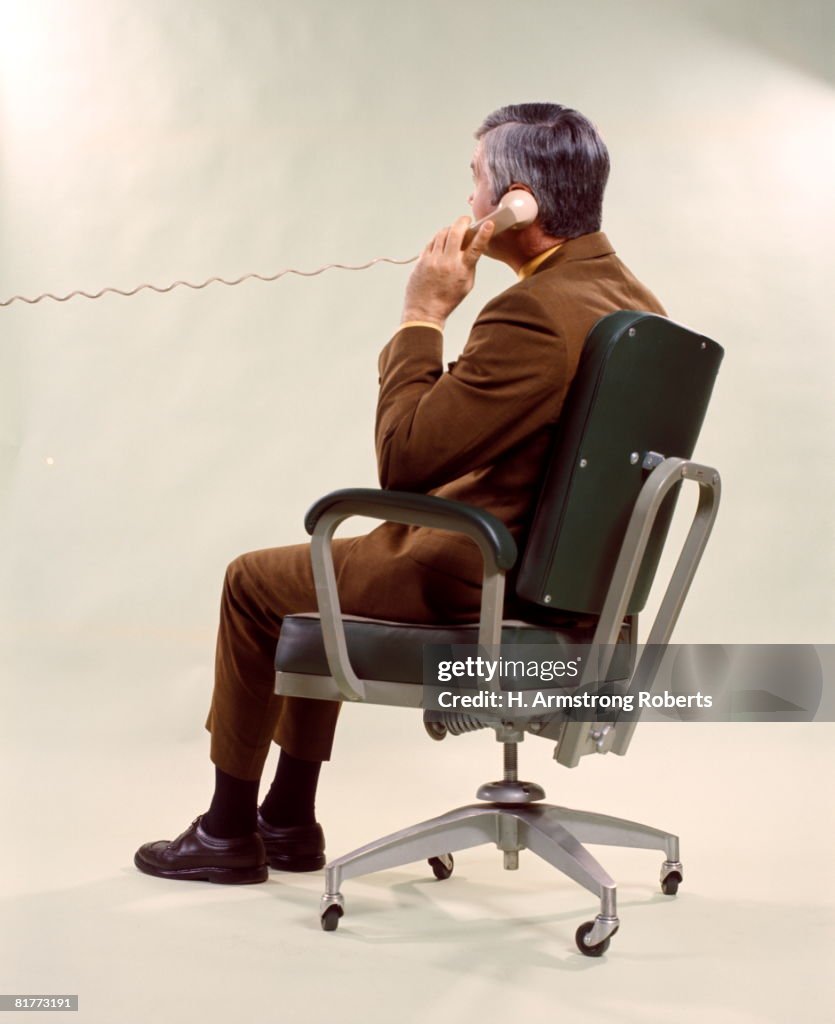 Man From Back Seated Metal Office Chair Talking On Telephone Men Business Businessman Businessmen.