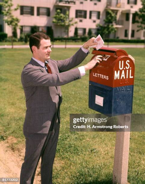 man business suit dropping letter into red blue letter box postal mailbox mail sending letters posting. - 1960 stock pictures, royalty-free photos & images