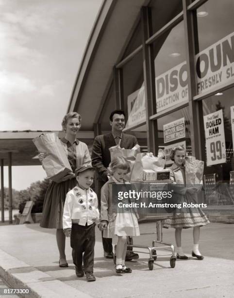 family carrying groceries home. - 1950s father stock-fotos und bilder