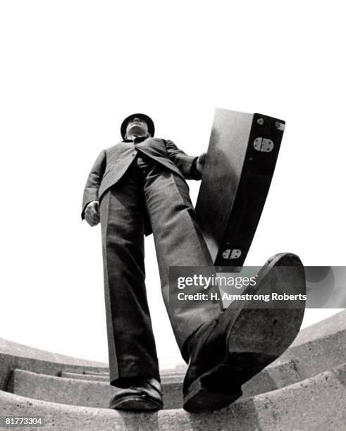 fish eye angle of salesman walking down stairs foot about to step on camera briefcase elongated body distortion tall big. - low angle view shoe stock pictures, royalty-free photos & images