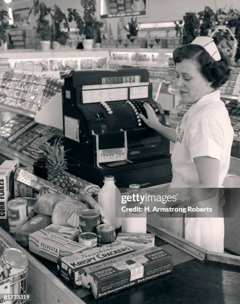 female grocery cashier ringing purchases. - retro style shopping stock pictures, royalty-free photos & images