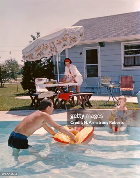 retro family in backyard, showing an in-ground swimming pool, father, mother, son, daughter, man, woman, boy, girl. - women swimming pool retro stock pictures, royalty-free photos & images