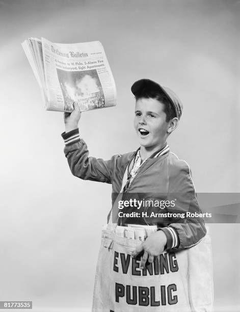 paperboy selling newspapers, holding paper up in one hand, with bag of papers over shoulder, philadelphia, pennsylvania, usa. (photo by h. armstrong roberts/retrofile/getty images) - zeitungsausträger stock-fotos und bilder