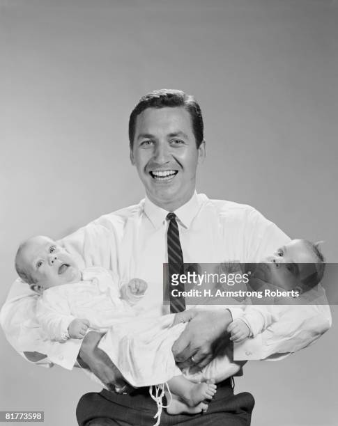 father holding twins, portrait. - 1960s baby stockfoto's en -beelden