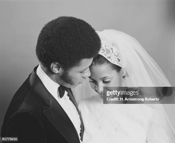 newlywed couple, groom leaning in towards bride, portrait. - african americans getting married stock pictures, royalty-free photos & images