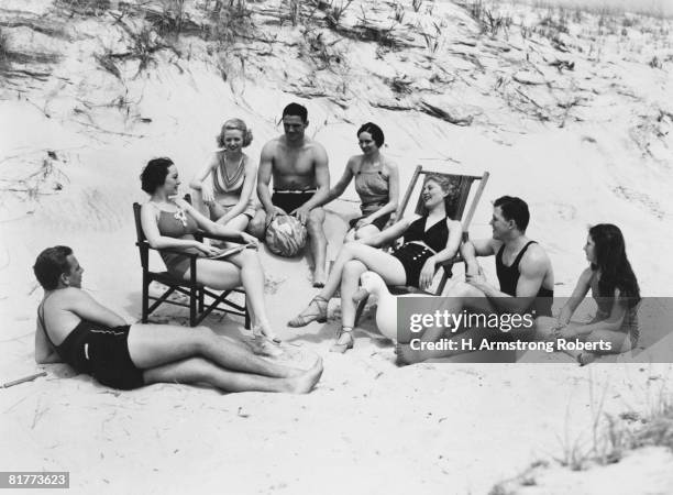 woman wearing bathing suit, sitting by wall. - 1930s beach stock pictures, royalty-free photos & images