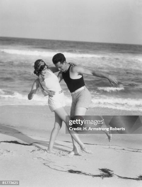 couple embracing on sandy beach. - 1920s stock-fotos und bilder