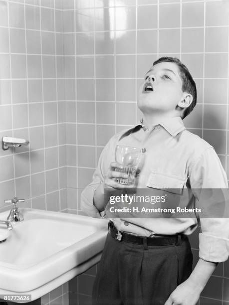 boy gargling in bathroom. - 1940 stock pictures, royalty-free photos & images