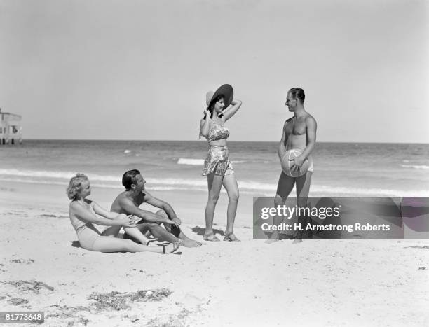 two couples standing on beach. - headware stock pictures, royalty-free photos & images