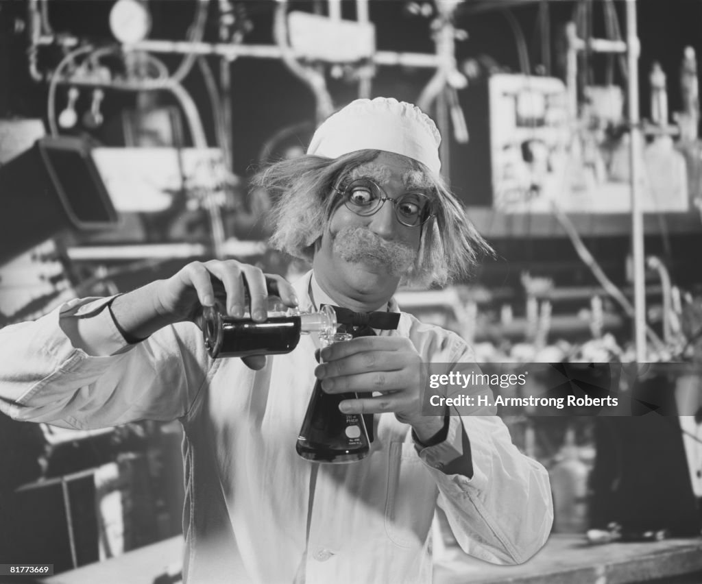 Mad scientist in laboratory, mixing chemicals.