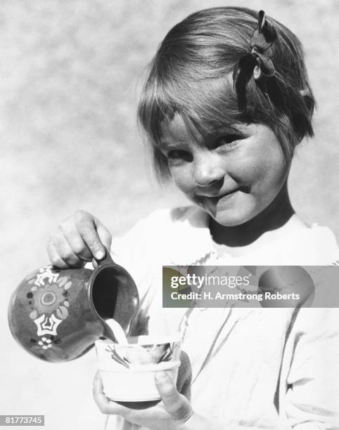 girl poring milk from pitcher into cup. - milk pitcher �ストックフォトと画像