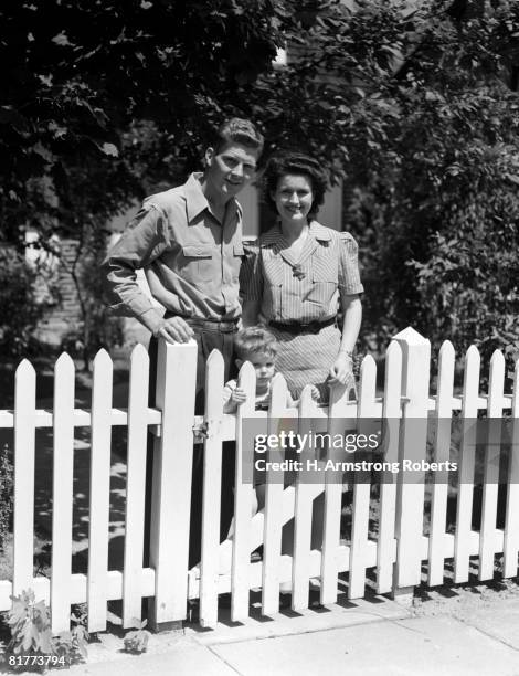 portrait of family in front of house with picket fence. - white picket gate stock pictures, royalty-free photos & images