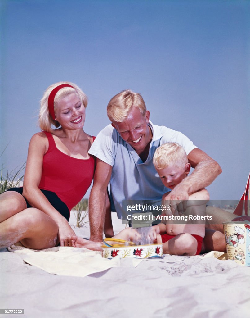 Family on the beach, boy playing in sand. (Photo by H. Armstrong Roberts/Retrofile/Getty Images)