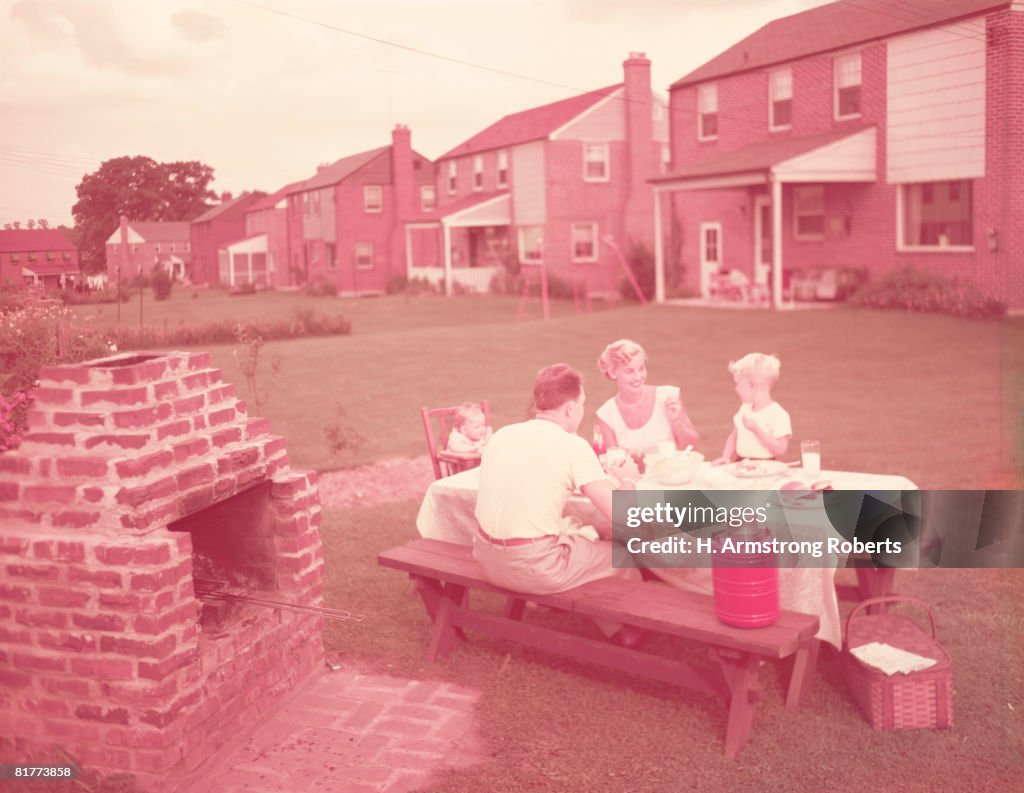 Family having picnic and grill in backyard. (Photo by H. Armstrong Roberts/Retrofile/Getty Images)