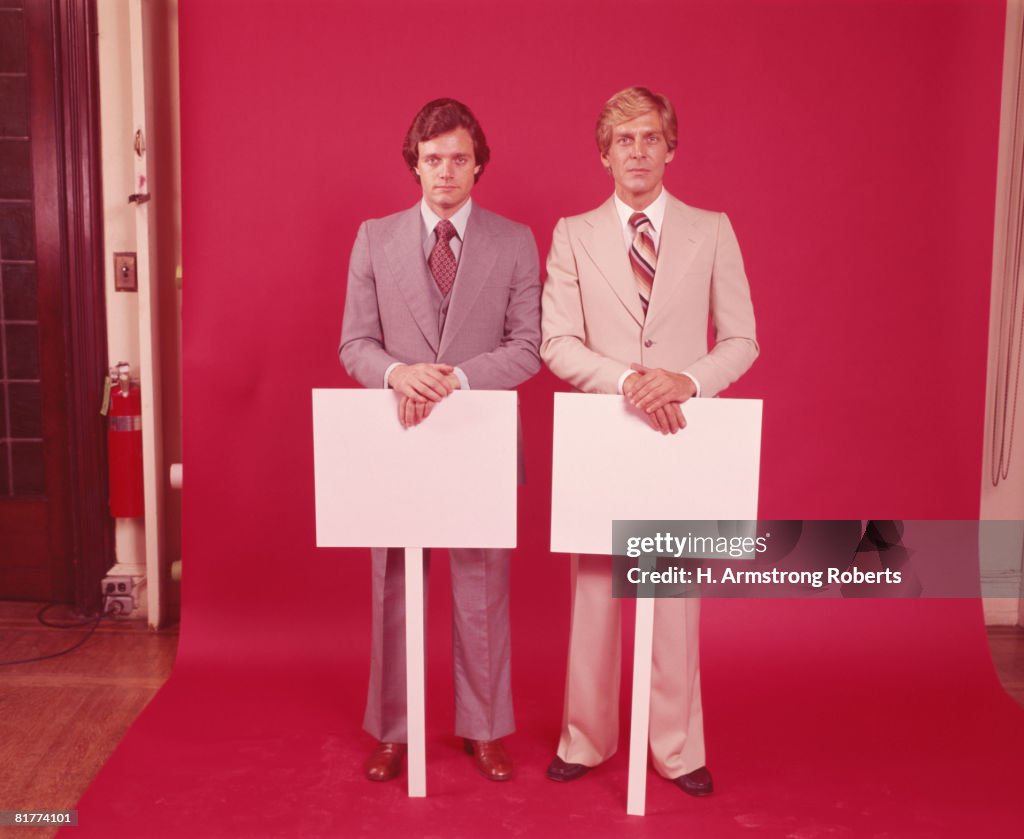 Two businessmen holding blank placards. (Photo by H. Armstrong Roberts/Retrofile/Getty Images)