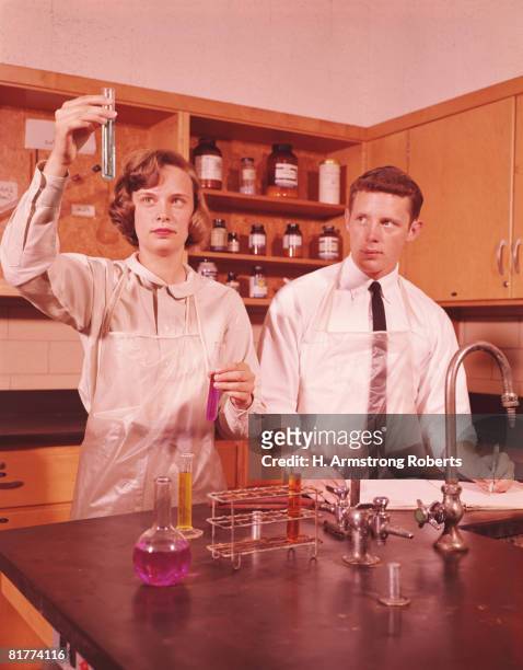two students in chemistry laboratory, girl holding up test tube, boy taking notes science. (photo by h. armstrong roberts/retrofile/getty images) - 1960 fotografías e imágenes de stock