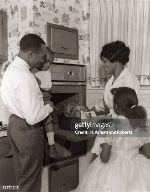 family looking at oven and roast turkey. - black and white christmas imagens e fotografias de stock