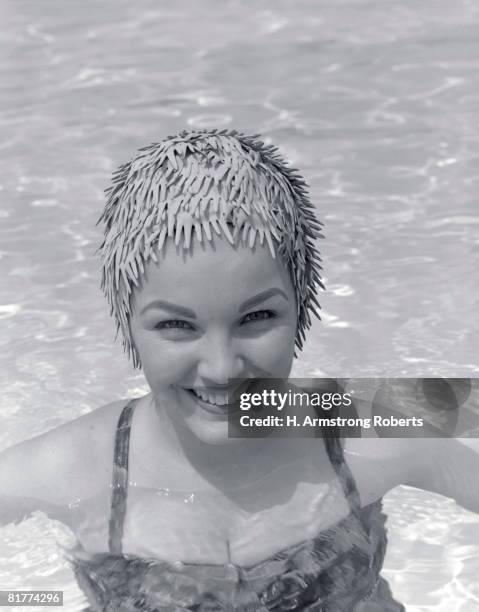 smiling woman in a swimming pool. - women swimming pool retro stock pictures, royalty-free photos & images