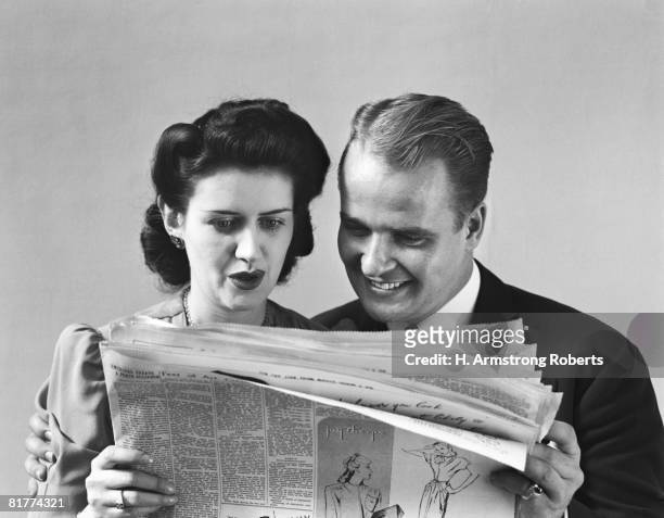 couple reading newspaper, woman looking worried. (photo by h. armstrong roberts/retrofile/getty images) - lee armstrong fotografías e imágenes de stock