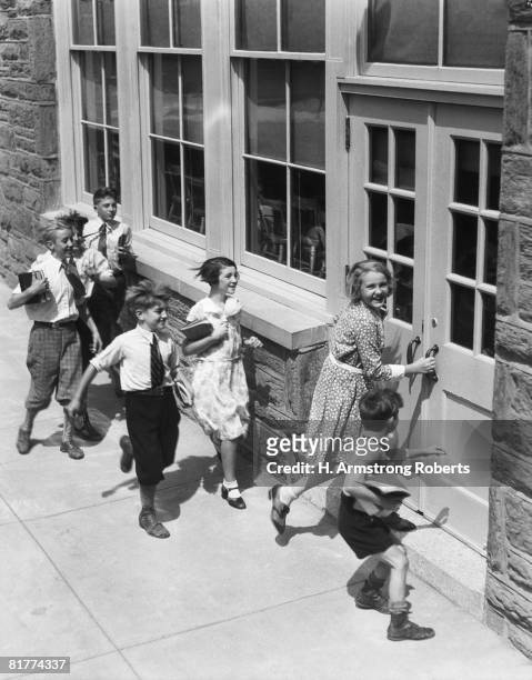 seven children carrying books, about to enter schoolhouse. (photo by h. armstrong roberts/retrofile/getty images) - retrofile foto e immagini stock