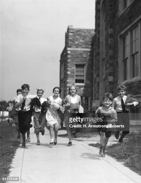 seven children running along pavement, outside schoolhouse. (photo by h. armstrong roberts/retrofile/getty images) - retrofile foto e immagini stock