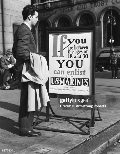 young man reading us marines recruitment post. (photo by h. armstrong roberts/retrofile/getty images) - retrofile foto e immagini stock