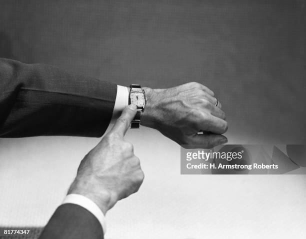 man's hand pointing at wristwatch. (photo by h. armstrong roberts/retrofile/getty images) - retrofile foto e immagini stock