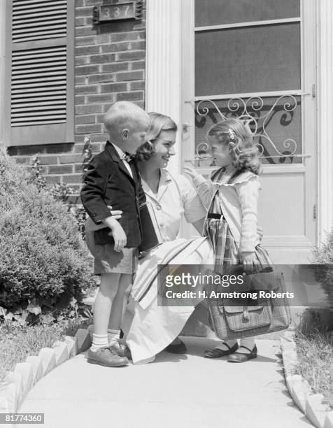 mother kneeling with son and daughter, outside house. (photo by h. armstrong roberts/retrofile/getty images) - retrofile foto e immagini stock