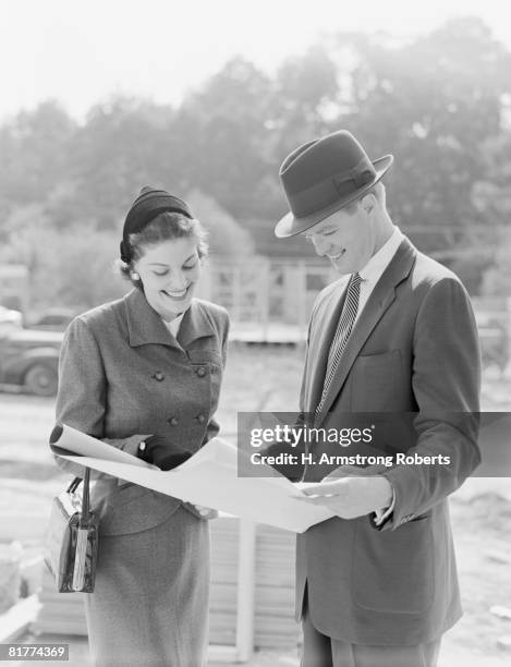couple reviewing blueprints at construction site. (photo by h. armstrong roberts/retrofile/getty images) - retrofile foto e immagini stock