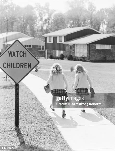two girls walking along suburban street. (photo by h. armstrong roberts/retrofile/getty images) - retrofile foto e immagini stock