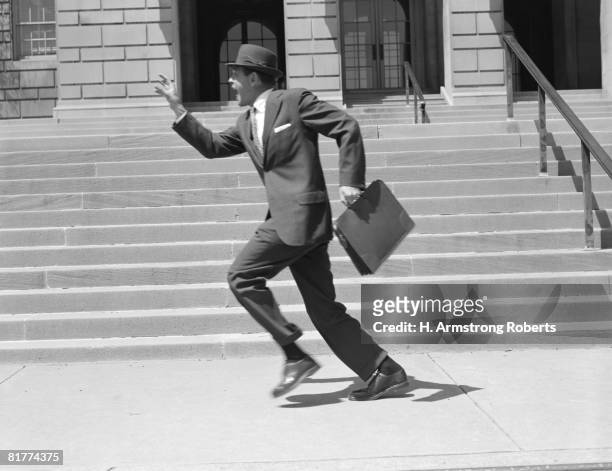 man carrying briefcase, running past stairs, low section. (photo by h. armstrong roberts/retrofile/getty images) - retrofile foto e immagini stock
