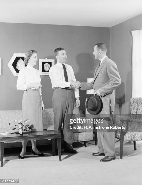 couple with salesman in home, men shaking hands. (photo by h. armstrong roberts/retrofile/getty images) - retrofile foto e immagini stock