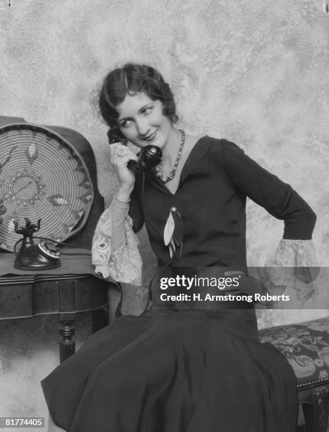 woman talking on telephone, smiling. (photo by h. armstrong roberts/retrofile/getty images) - women in the 1920's stockfoto's en -beelden