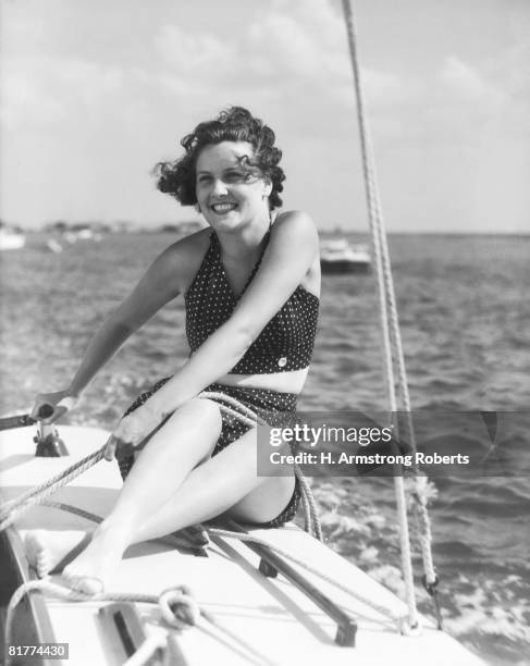 woman in swimsuit, on sailing boat, holding rope, smiling. (photo by h. armstrong roberts/retrofile/getty images) - retrofile foto e immagini stock