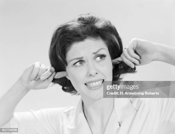 woman sticking fingers in her ears. - woman fingers in ears stock pictures, royalty-free photos & images