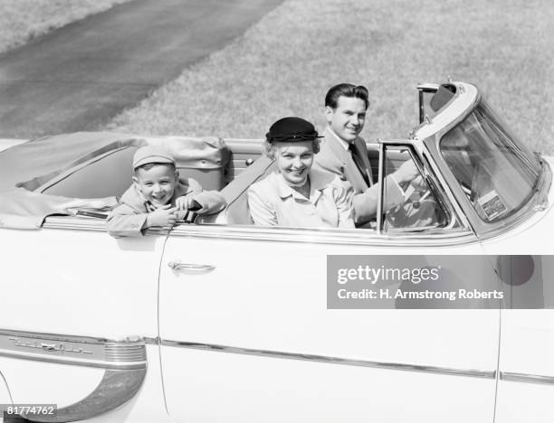 family of three sitting in convertible car, smiling, portrait. - 1950's cars stock pictures, royalty-free photos & images