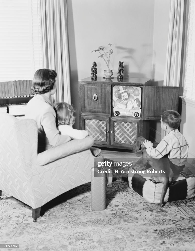 Mother and children watching television.