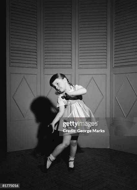 a little girl strikes a curiously dramatic pose against a screen backdrop, circa 1950. (photo by h. armstrong roberts/retrofile/getty images) - retrofile foto e immagini stock