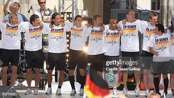 Members of the German national football team greet fans gathered at the Fan Mile in front of the Brandenburg Gate upon the team's arrival on June 30,...