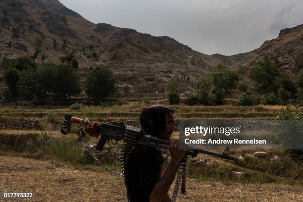 Member of the Afghan Local Police walks past the area where the United States dropped the GBU-43/B Massive Ordnance Air Blast, nicknamed the "Mother...